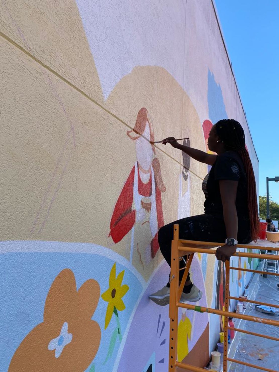 Marie Saint-Cyr painting a mural at SIBSPlace in 2023 in Rockville Centre, New York.