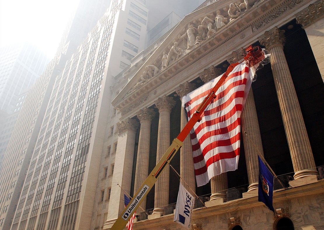 A huge United States flag is draped across the front of the New York Stock Exchange September 15, 2001 in preparation for its reopening on September 17 in New York City. The stock exchange had been closed since two hijacked commercial airliners were deliberately crashed into the World Trade Center's twin towers on September 11.